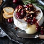 Baked Brie with Cranberry Jam on silver tray.