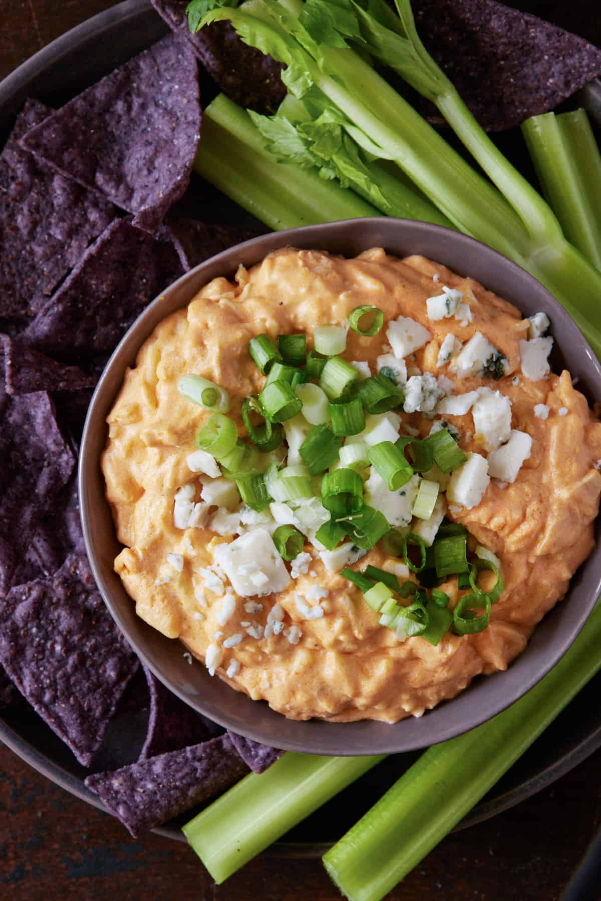 Buffalo Chicken Dip in a bowl with green onions on top.