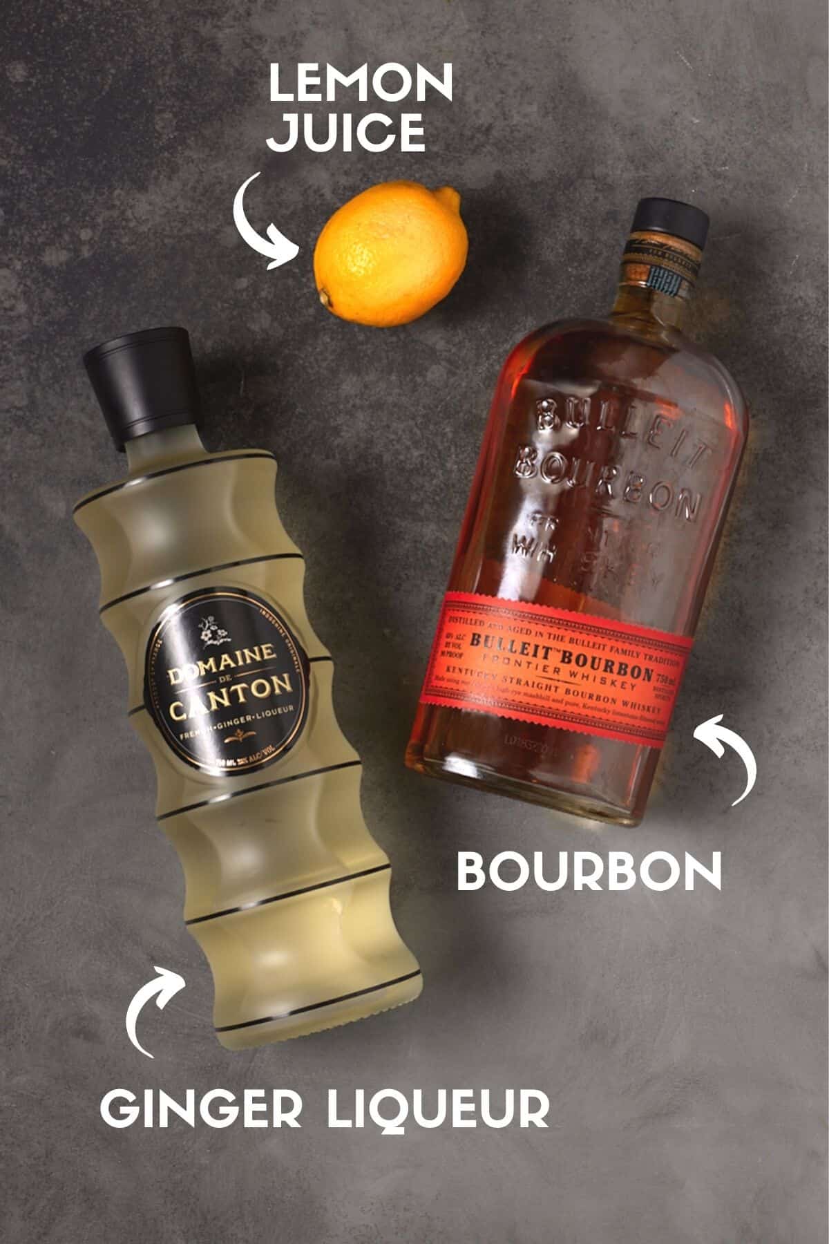 Bottles of bourbon and ginger liqueur with a lemon on a gray board. 