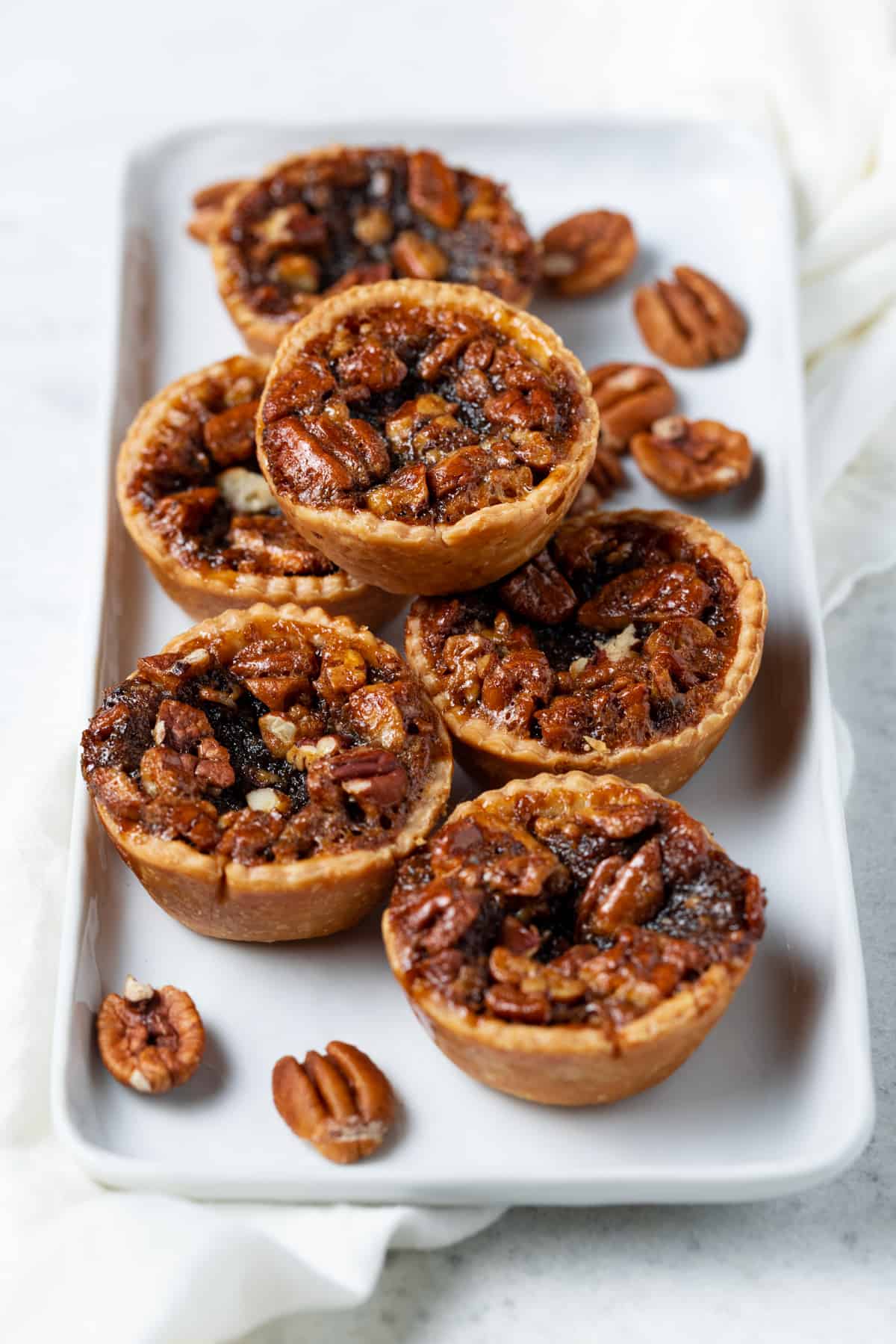 Mini pies stacked on white tray.