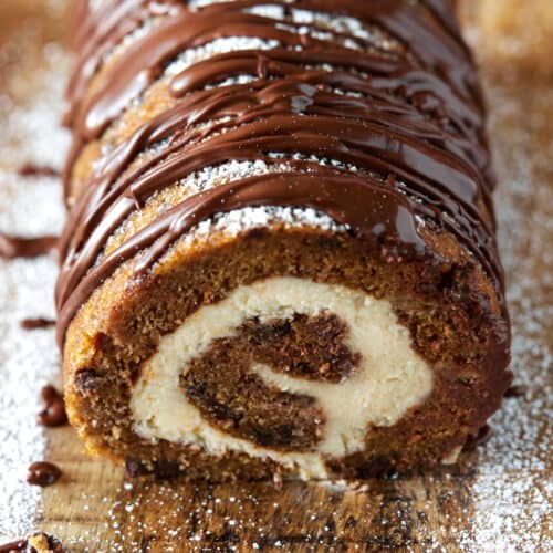 Pumpkin Chocolate Swiss Roll Cake on a cutting board.