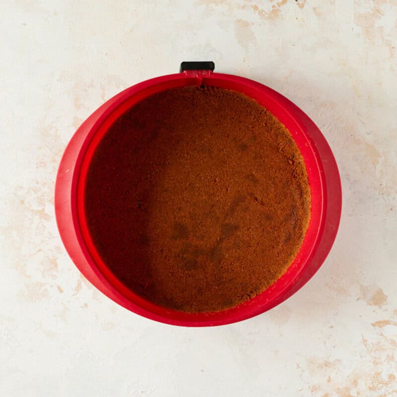 Biscoff cookie crust pressed into the bottom of a springform pan.