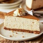 Slice of biscoff cheesecake on a cream plate.