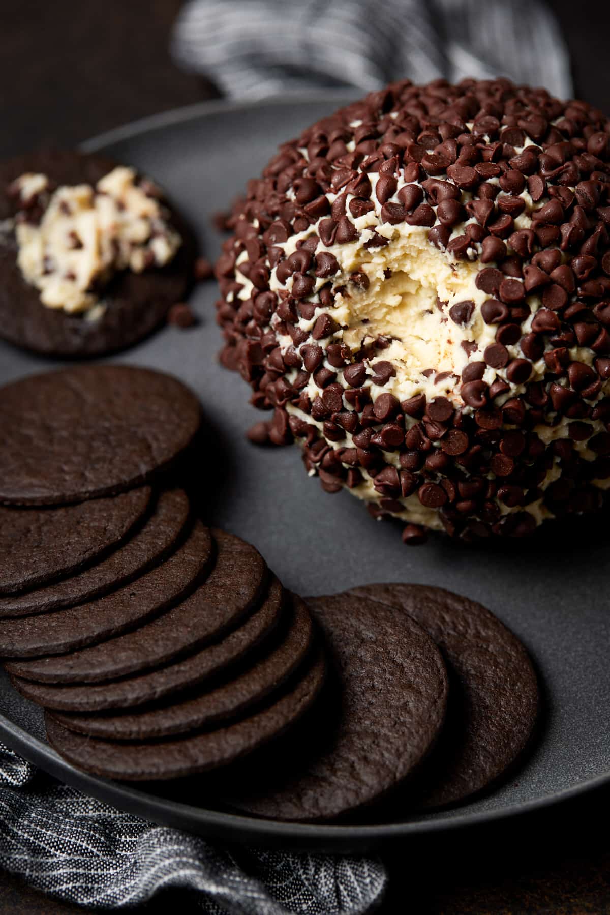 Cheesecake ball on plate with chocolate cookies. 