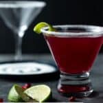 Filled martini glass with sugared rim and lime wedge.