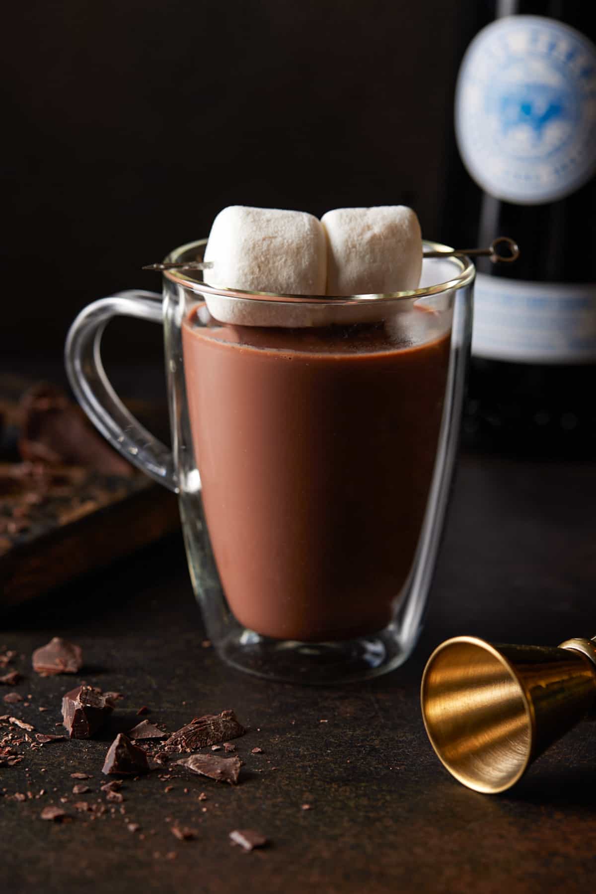 Glass mug filled with hot chocolate and garnished marshmallows. 