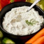 Dill dip in bowl with fresh veggies for eating.