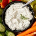 Dill dip in a bowl with fresh veggies.