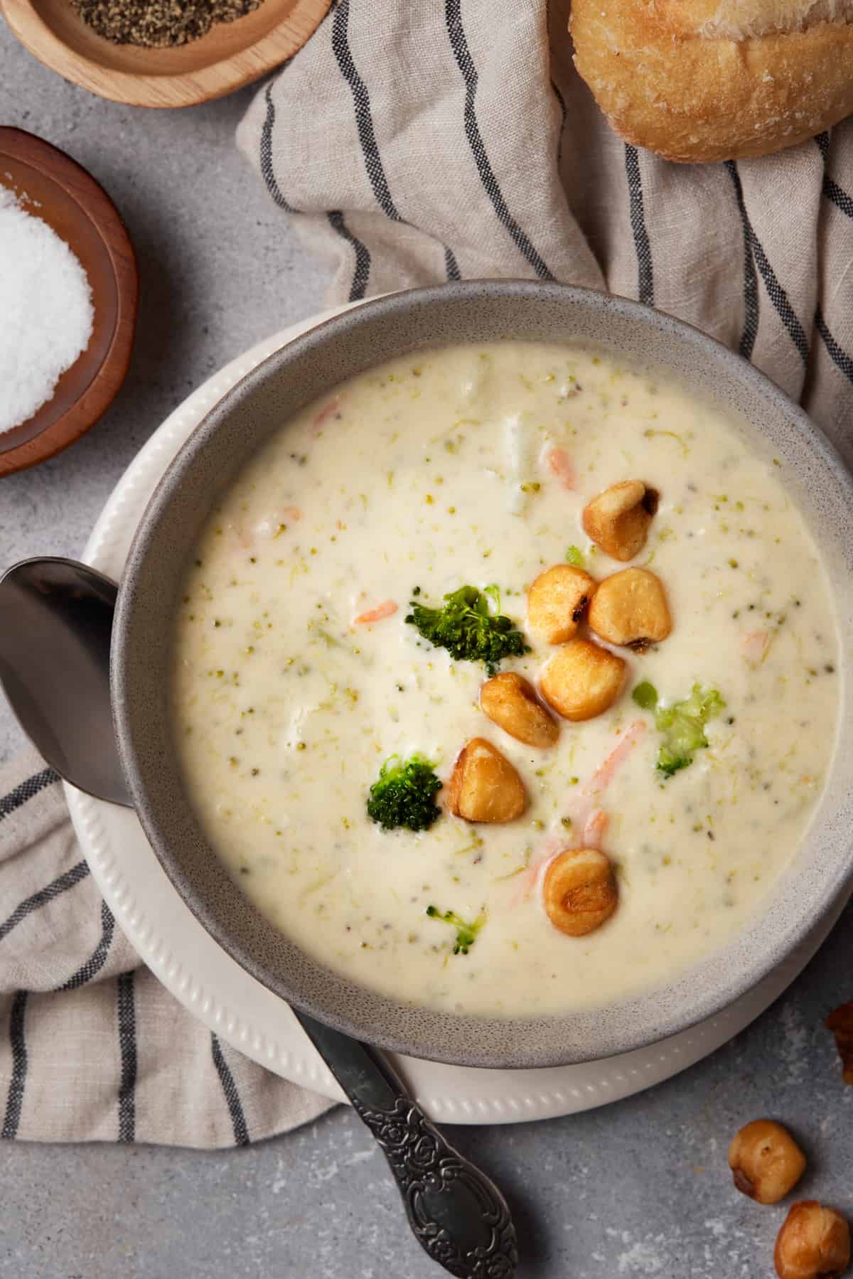 Bowl filled with soup and topped with corn nuts and broccoli.