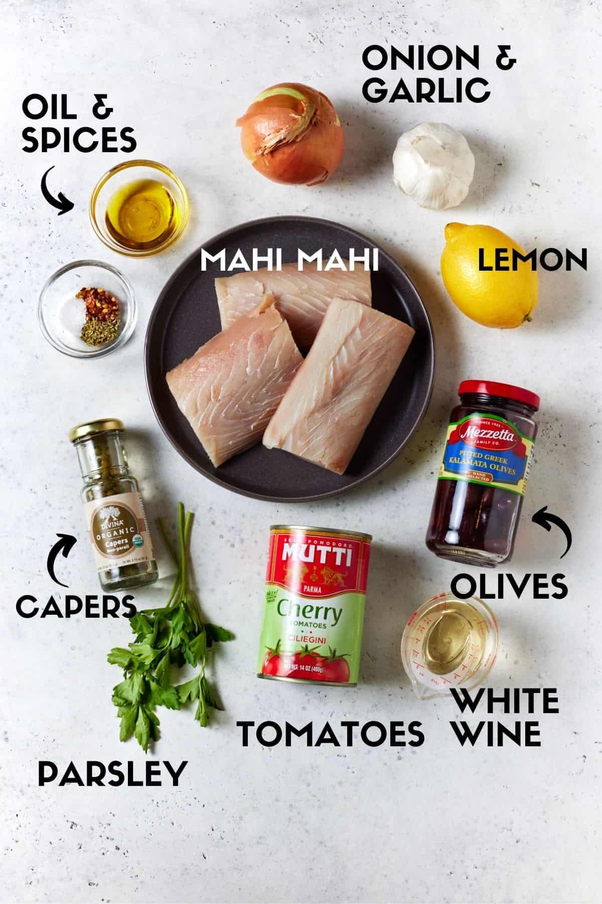 Baked mahi mahi ingredients including fish fillets, canned tomatoes, olives and capers. 