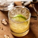Golden Margarita in glass with empty glass behind it.