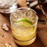 Margarita with a salted rim and a lime in a low ball glass