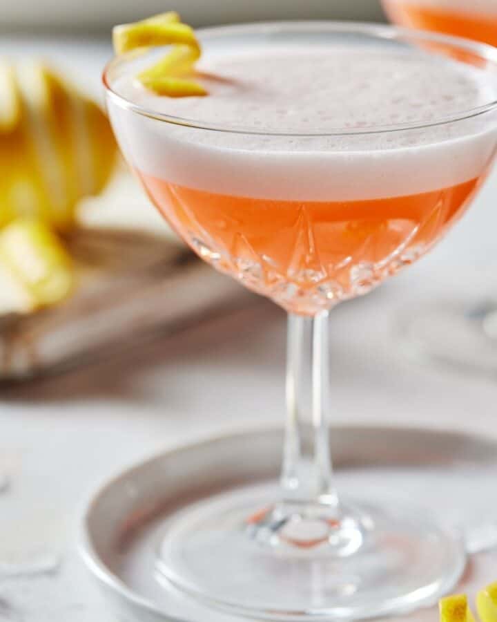 Coupe glass filled with pink drink and foamy top.