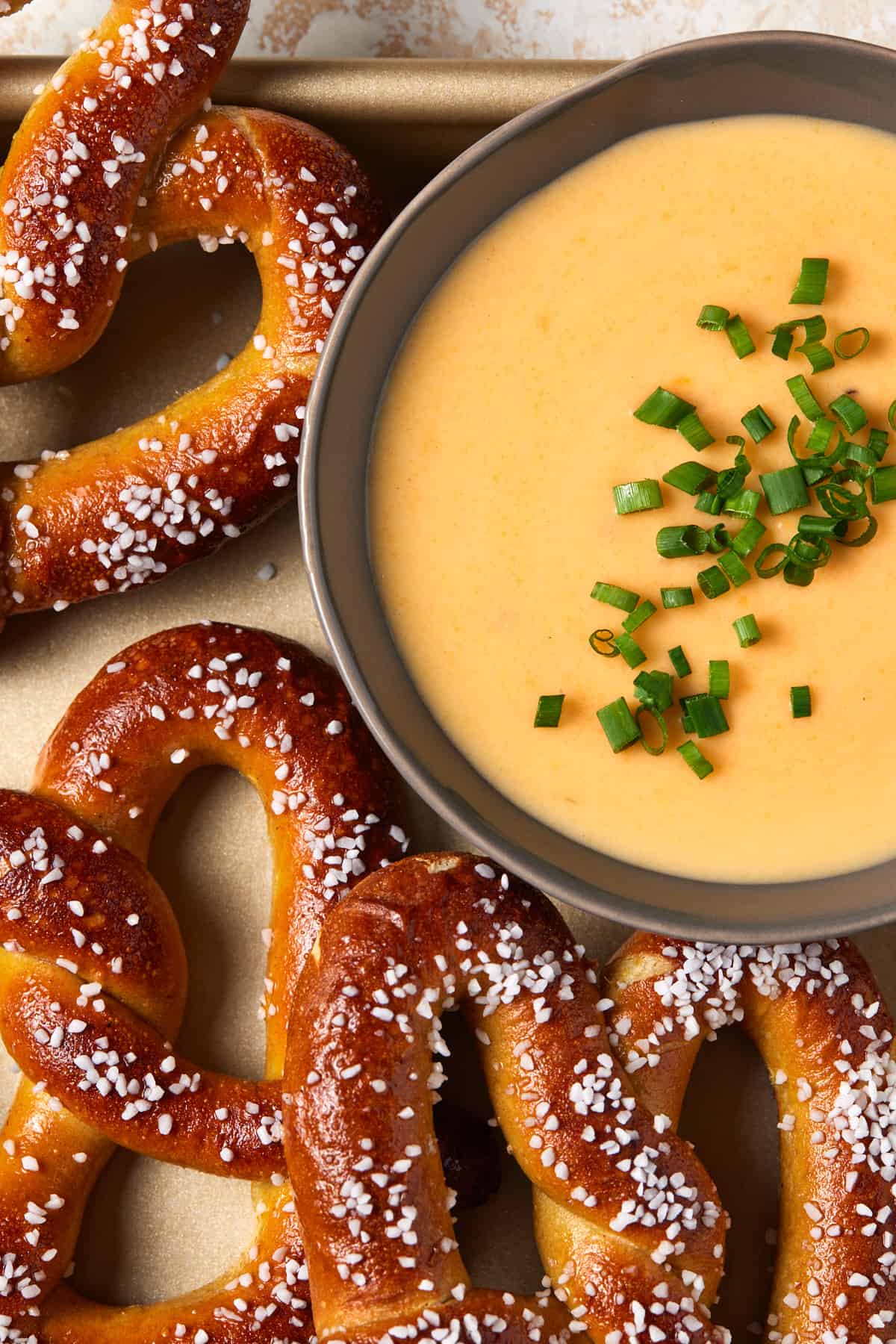 Cheese dip on tray with soft pretzels. 