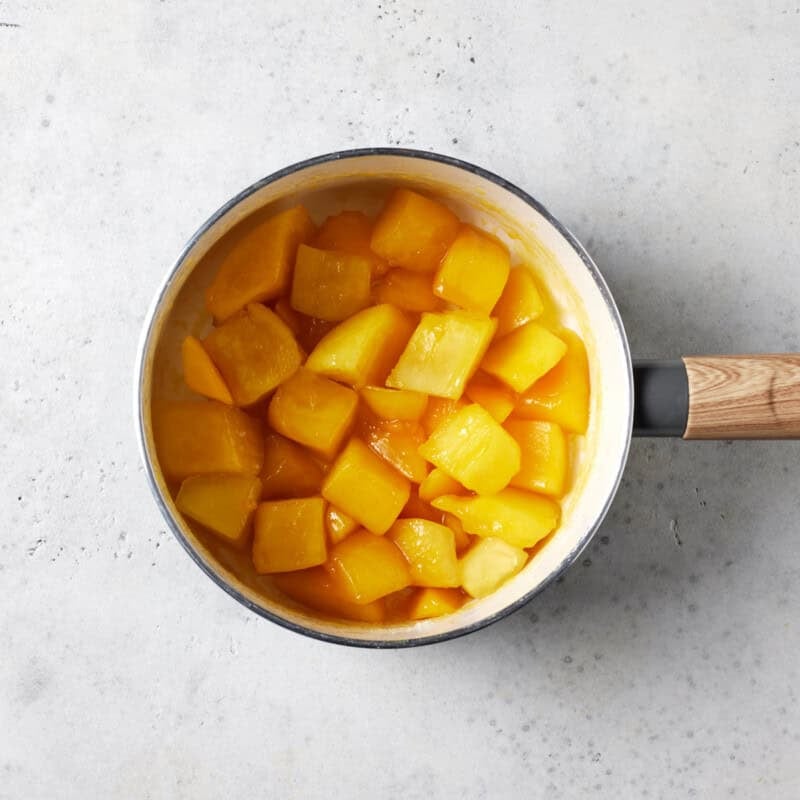 Mango cubes simmering in small saucepan. 