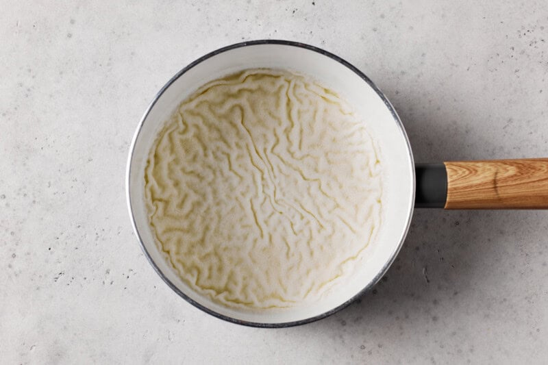 Gelatin sprinkled on milk in a saucepan. 