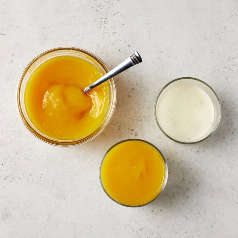 Mango puree spread on top of panna cotta in ramekins. 
