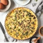 Cooked quiche with chives and parmesan cheese.