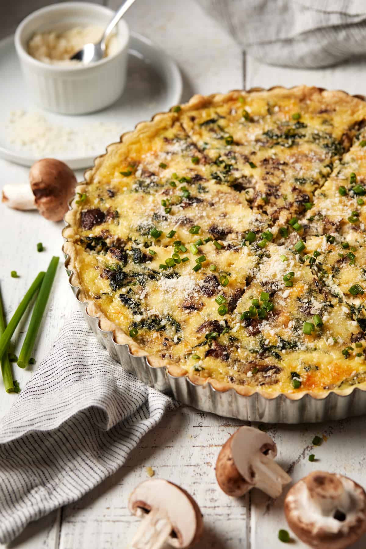 Quiche Florentine in pan with sliced mushrooms.