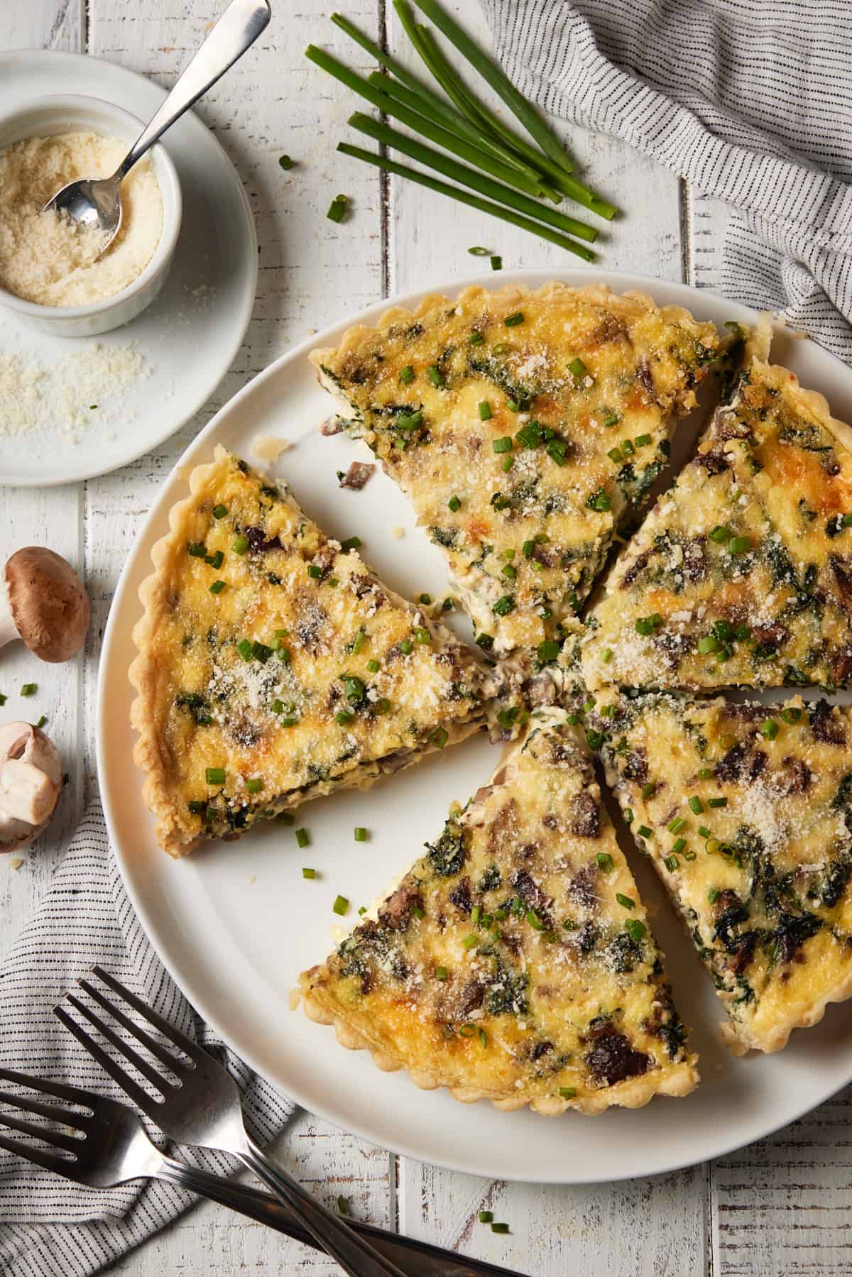 Sliced quiche on plate with parmesan cheese sprinkled on top.