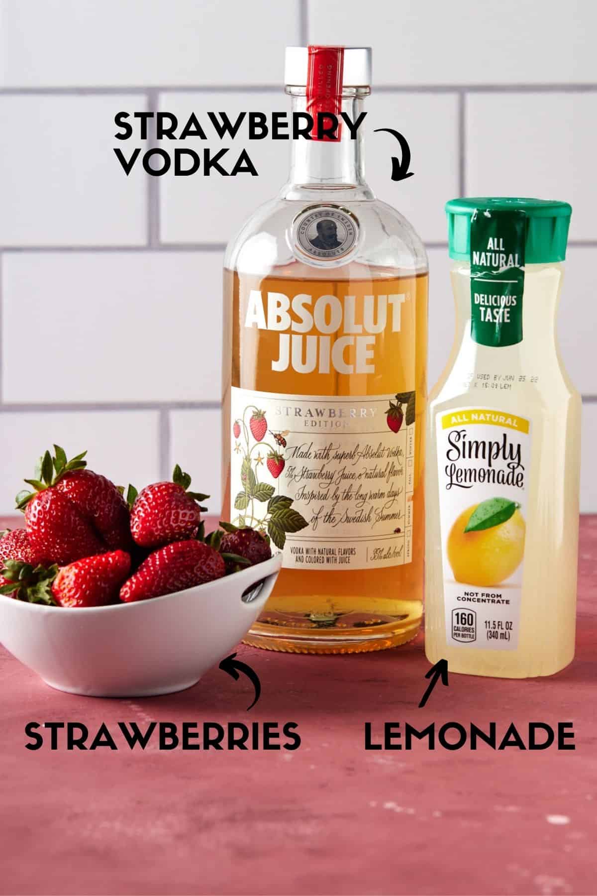 Strawberries, lemonade and strawberry vodka on a pink board. 