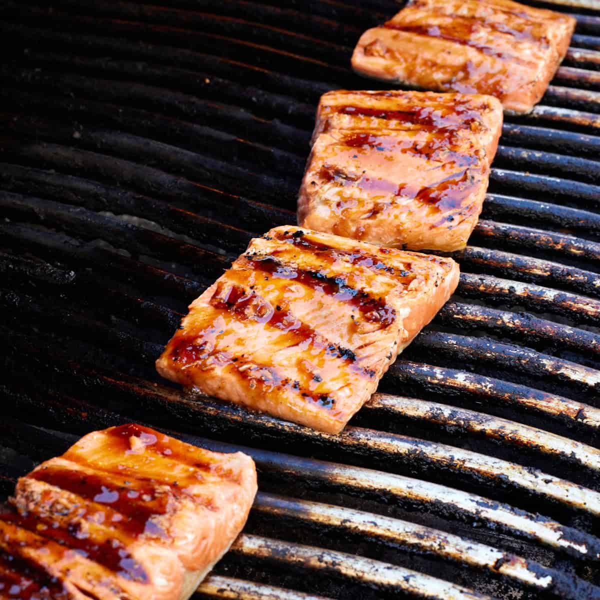 Cooked sockeye salmon fillets on grill grates. 