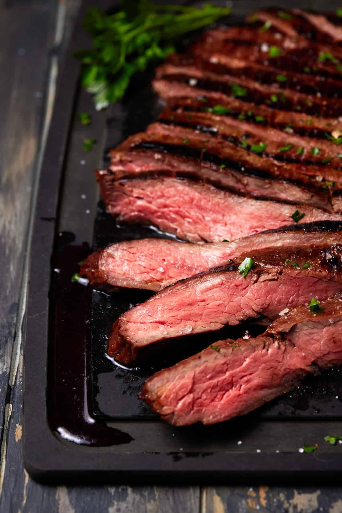Sliced flank steak on tray.