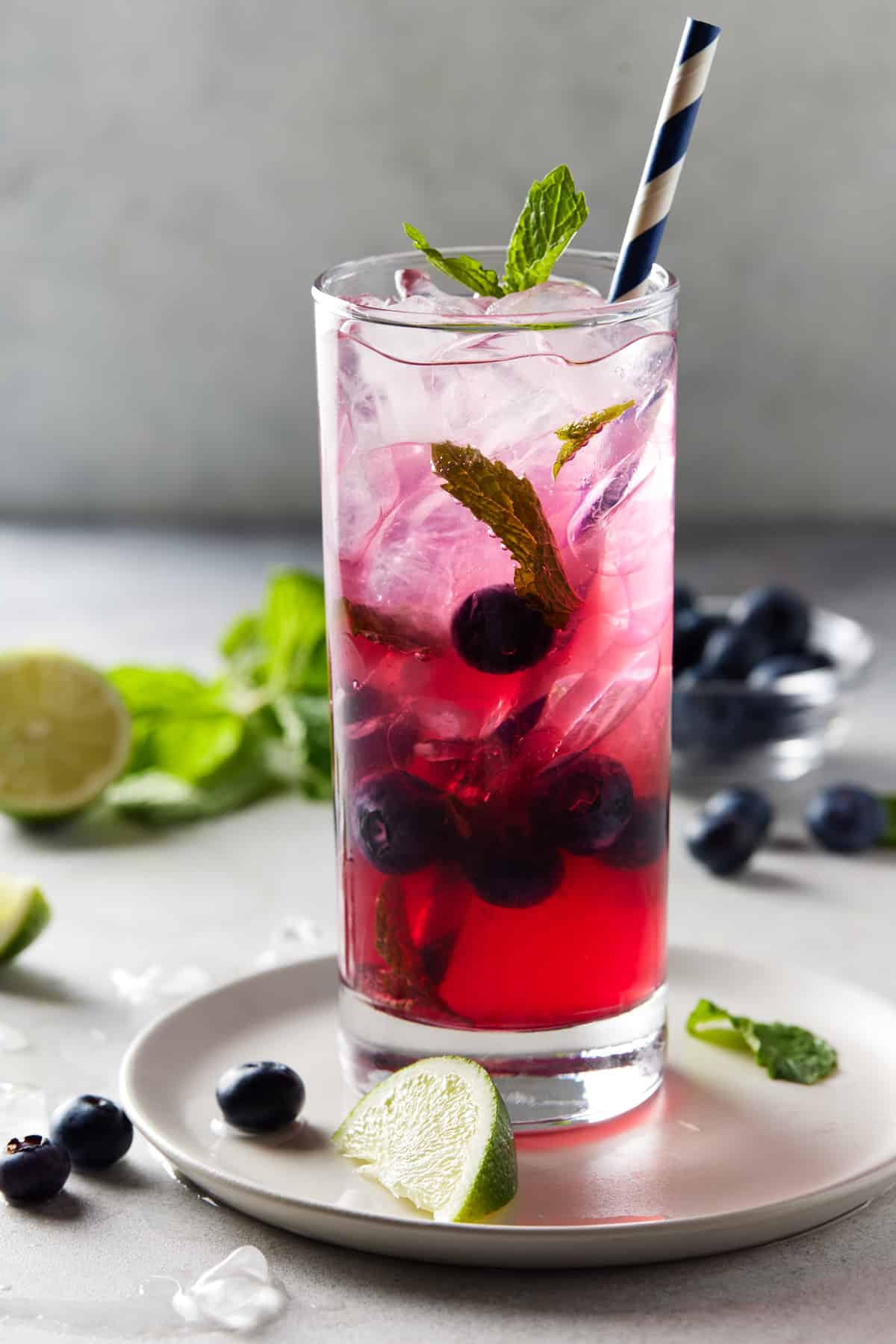 Blueberry Mojito in high ball glass with fresh limes.