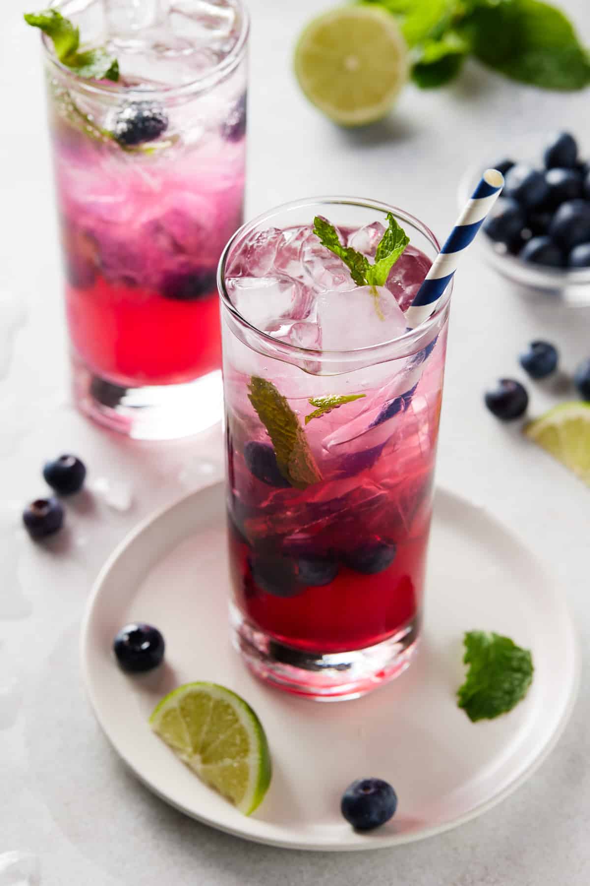Blueberry mojitos in glasses with fresh berries and mint.