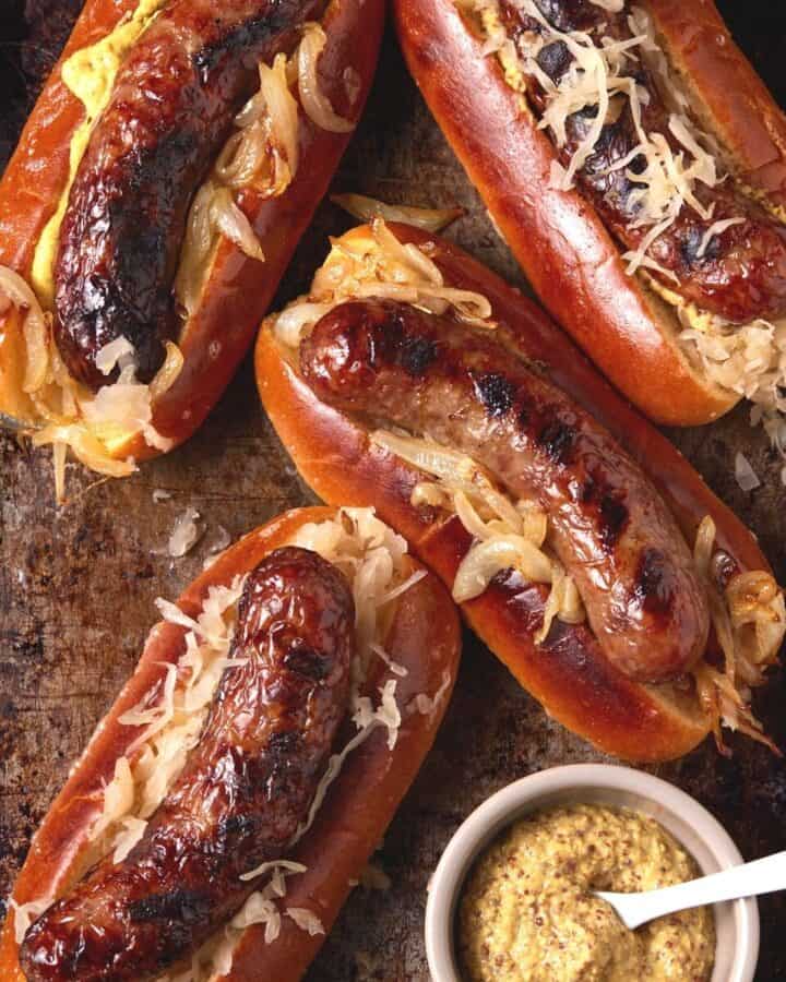 grilled brats in buns with sauerkraut.
