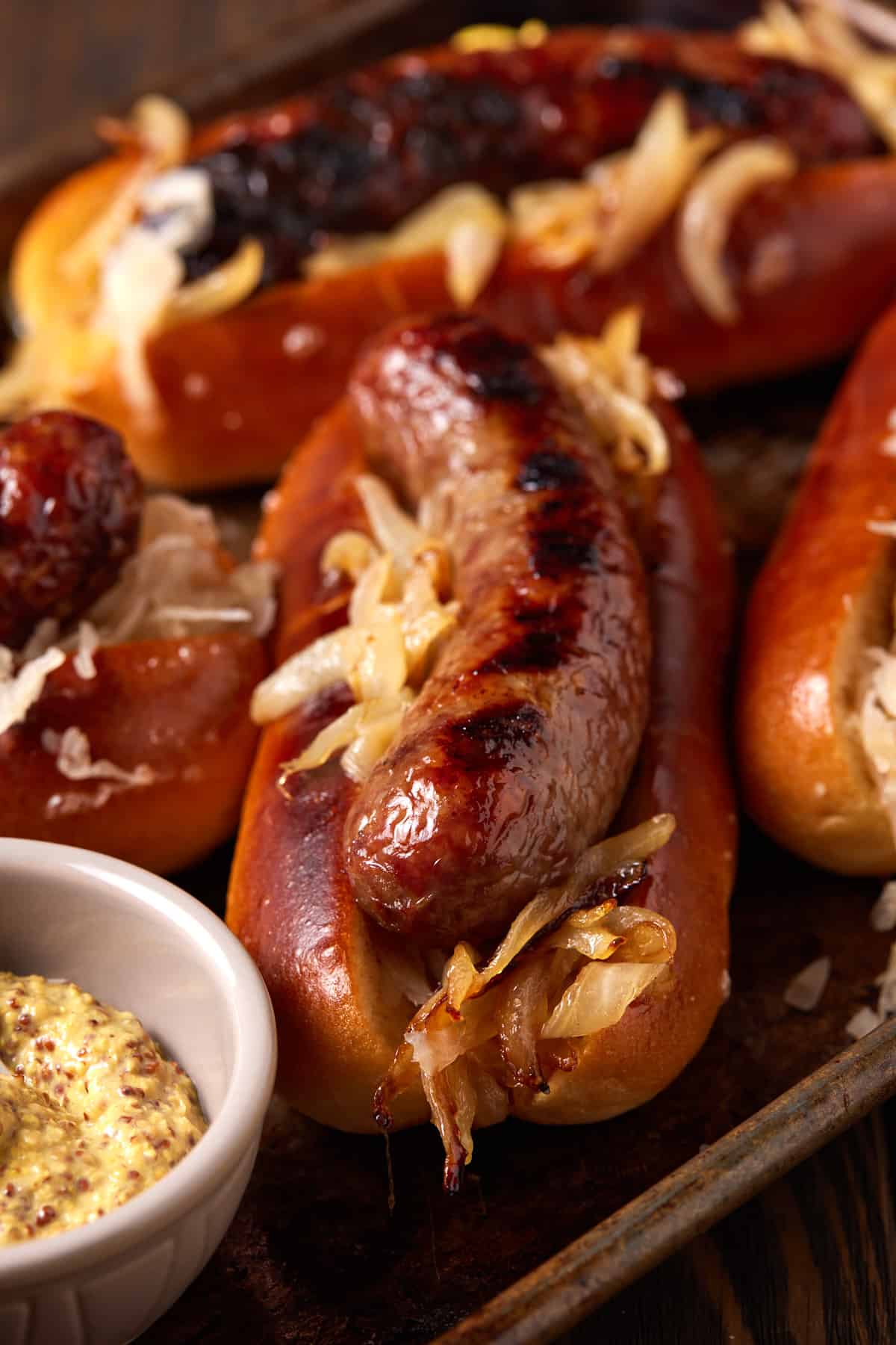 Grilled brats with brown mustard.