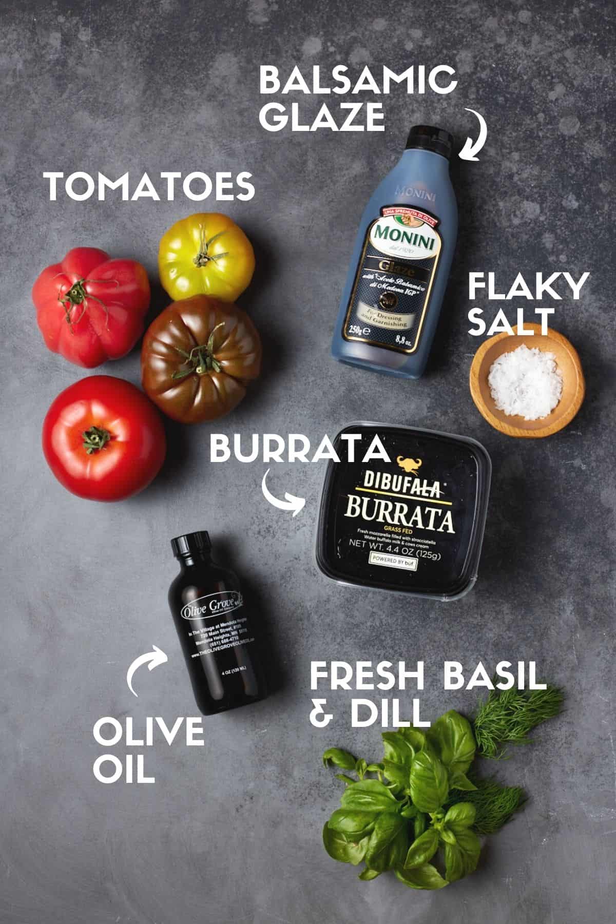 Ingredients for burrata caprese salad including tomatoes, cheese, herbs, salt and olive oil. 