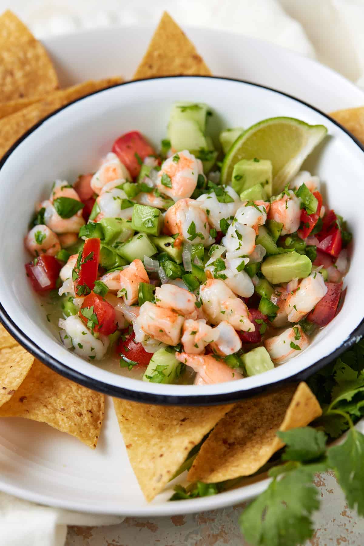 Ceviche in bowl with fresh lime and tortilla chips.