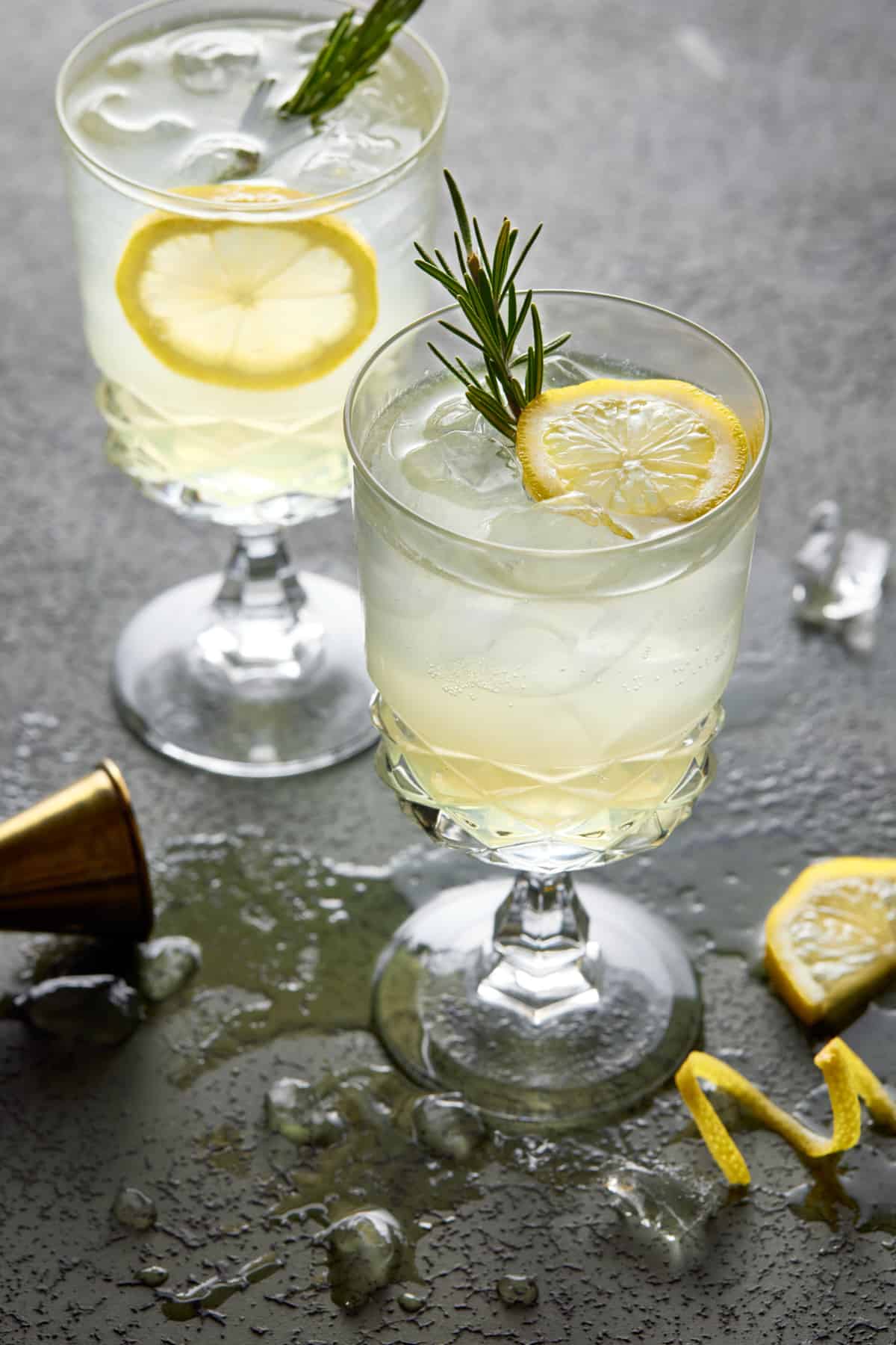 Two footed glassed filled with limoncello spritz cocktails and garnished with lemon slices. 