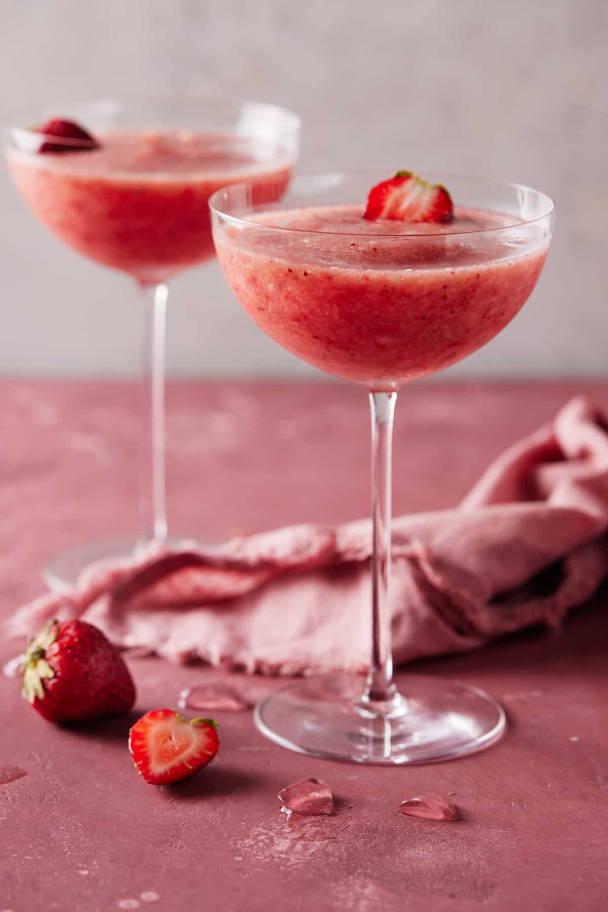 Frozen Rosé in coupe glasses with fresh strawberries for garnish.