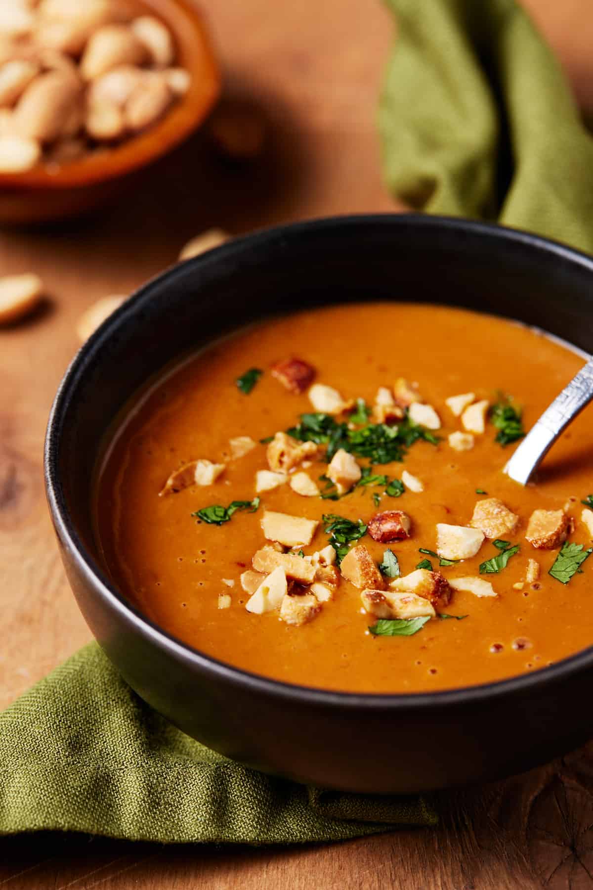 Thai Peanut Sauce in a bowl with fresh peanuts.