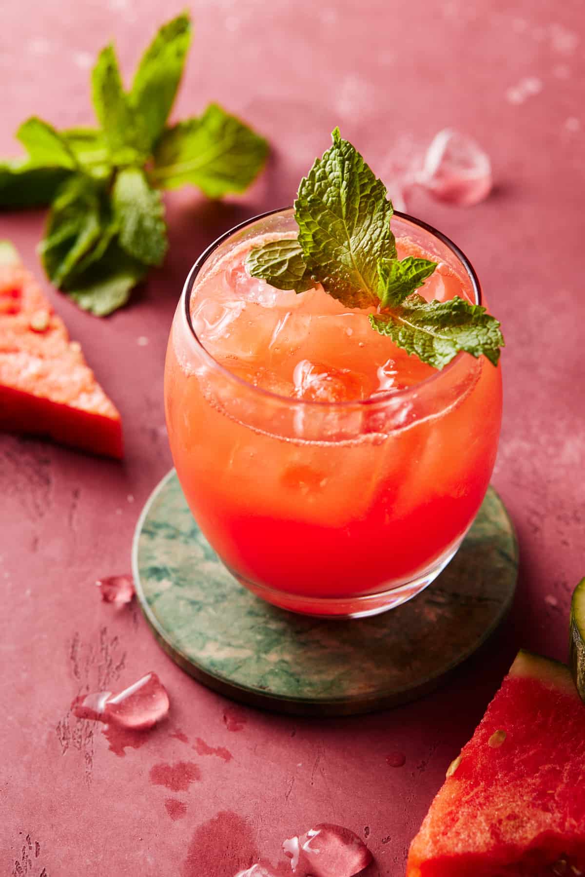 Watermelon Gin punch in low ball glass with ice and fresh watermelon.