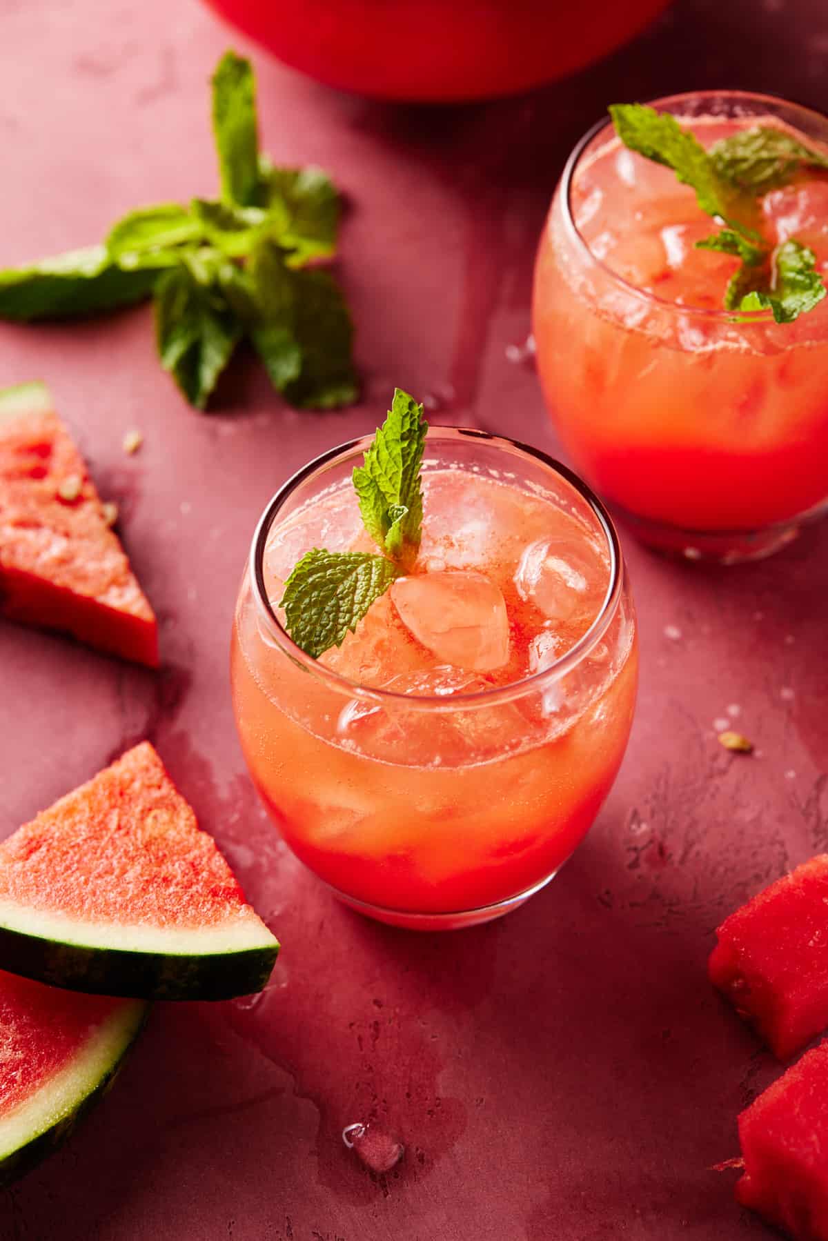 Glasses of watermelon punch with pitcher.