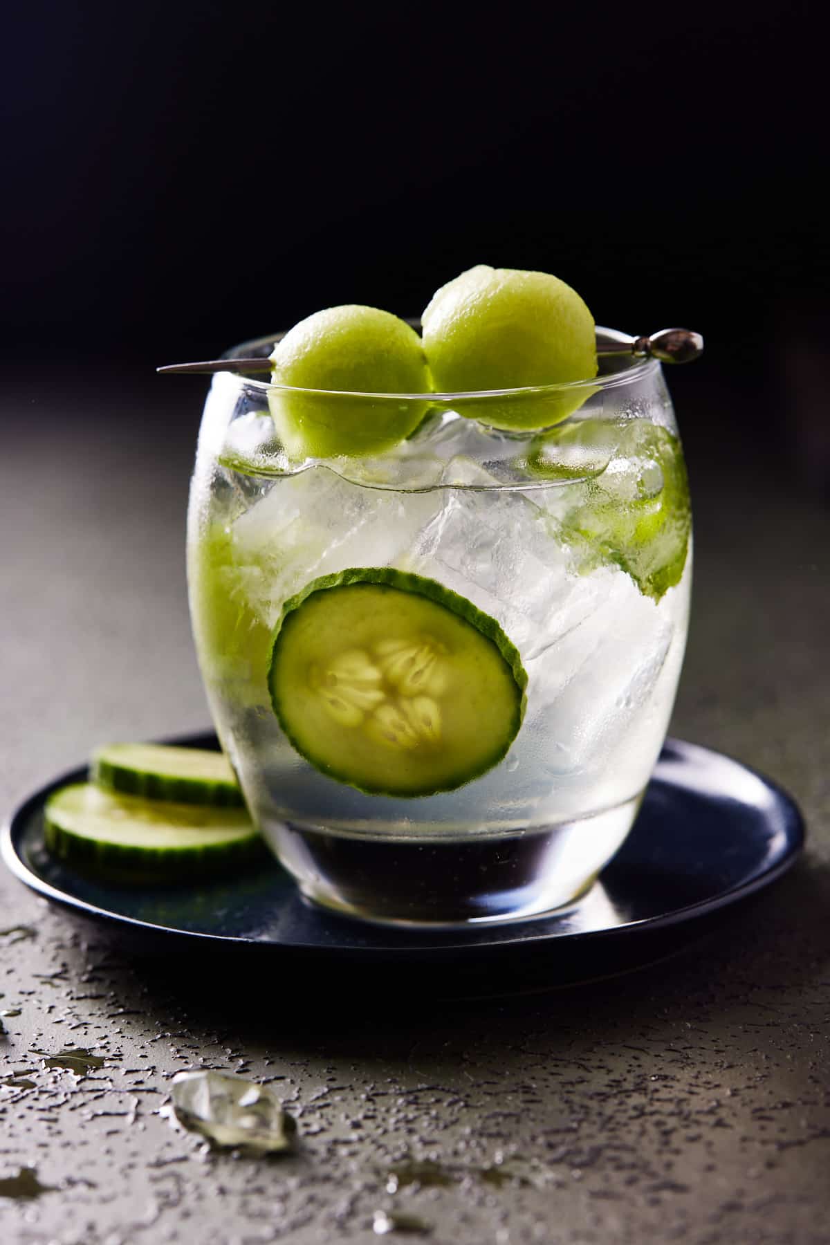 Lowball glass with spa water sangria, garnished with honeydew melon and cucumber. 