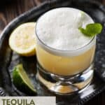 Tequila sour with lemon and lime wedges.
