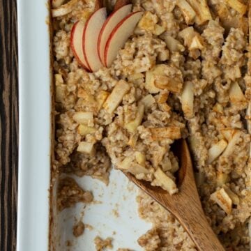 White casserole dish with baked steel cut oatmeal and apples.