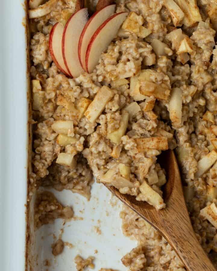 White casserole dish with baked steel cut oatmeal and apples.