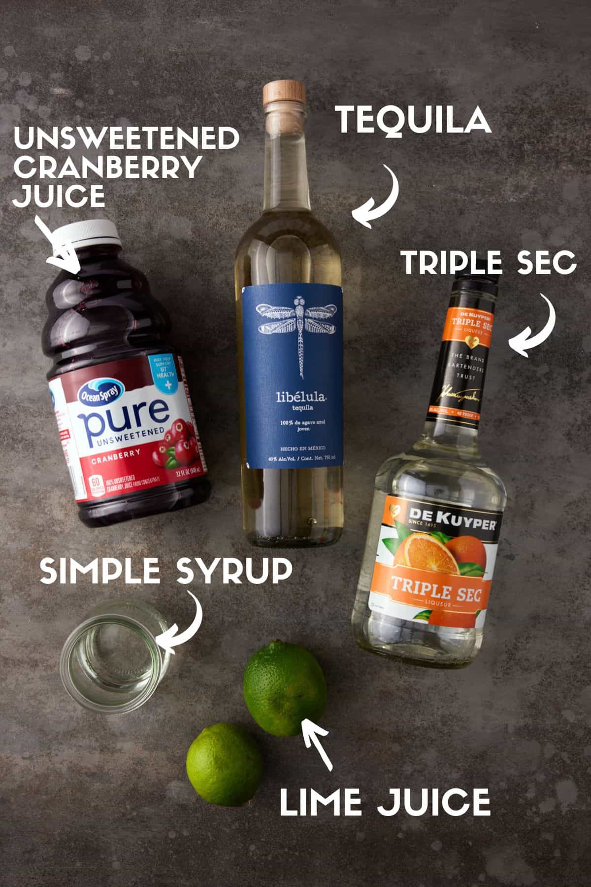 Bottles of tequila, triple sec, cranberry juice, limes and simple syrup.