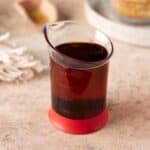 Red beaker filled with demerara syrup.