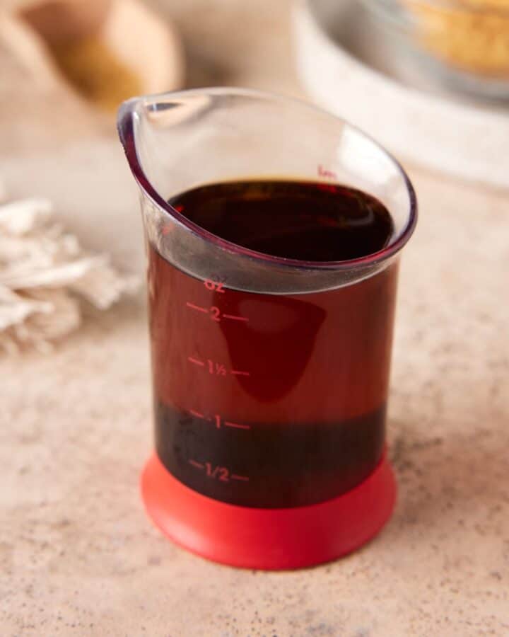Red beaker filled with demerara syrup.