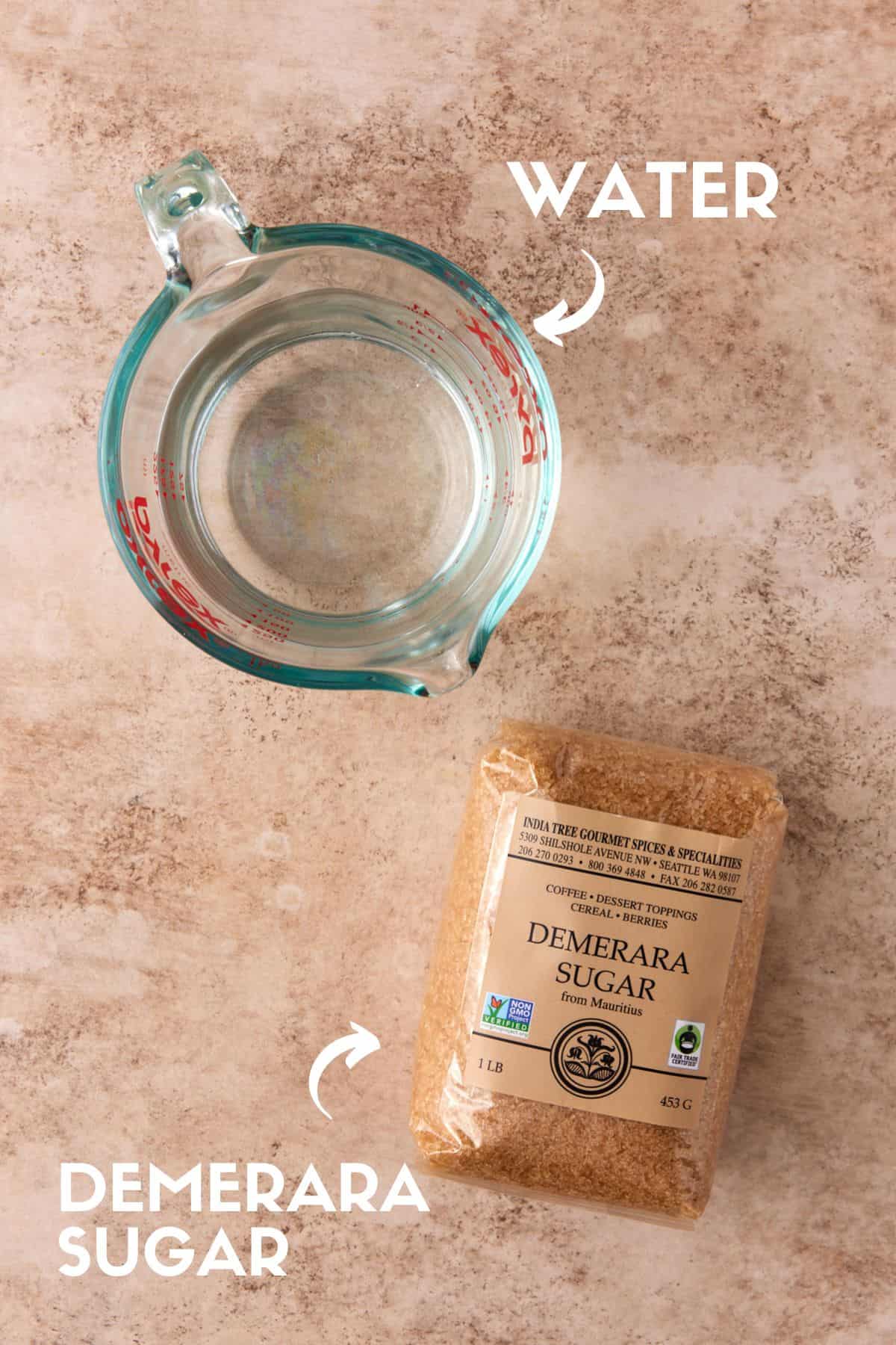 Glass measuring cup with water and package of demerara sugar. 