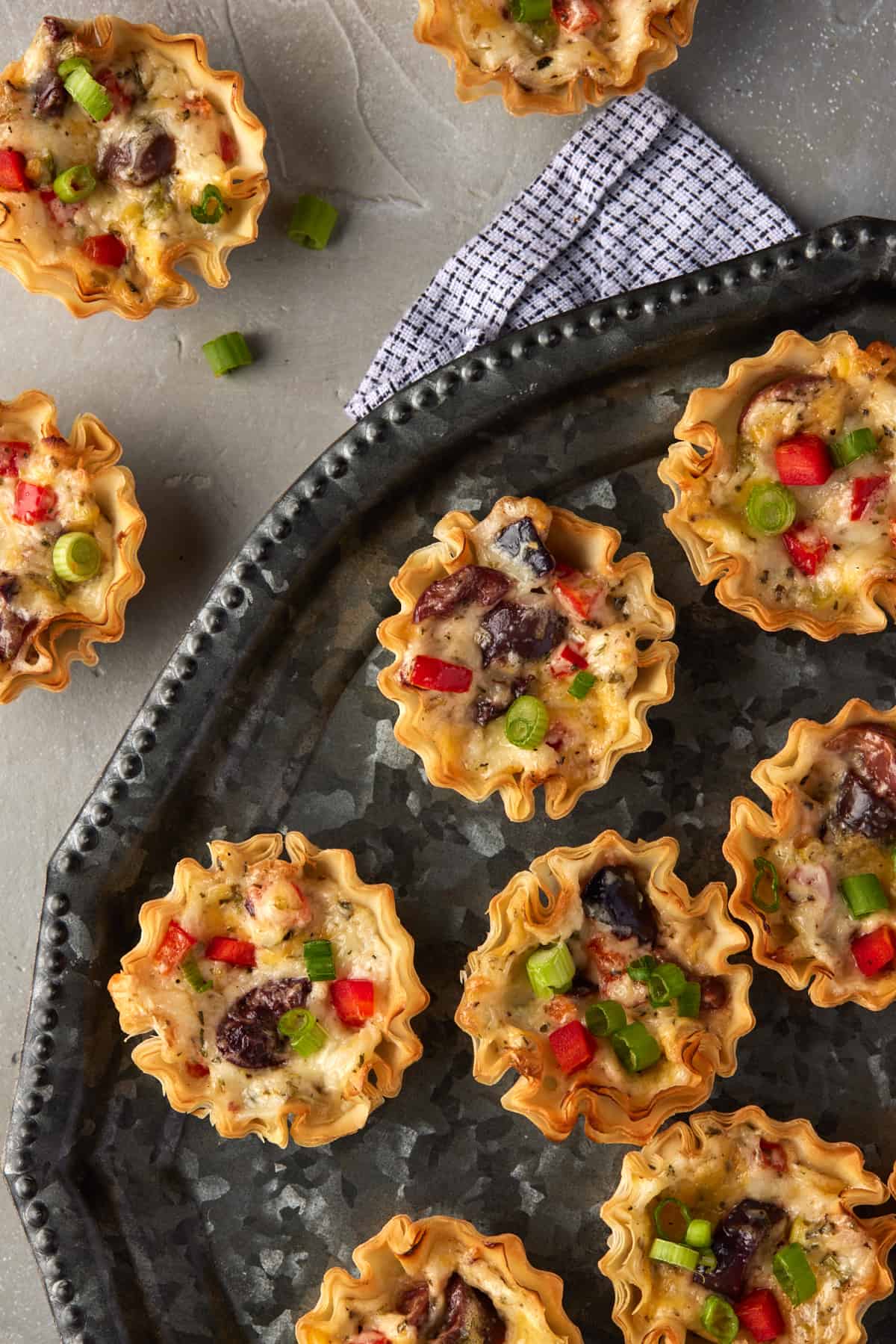 Filled phyllo cups with green onions and red peppers.