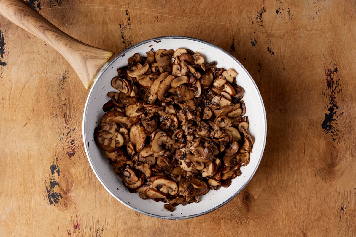 White skillet with sauteed mushrooms. 