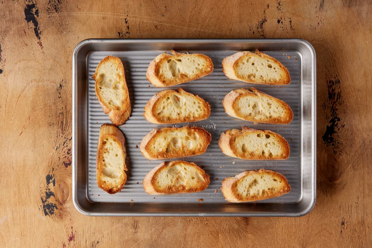 Sheet pan with toasted baguette slices. 