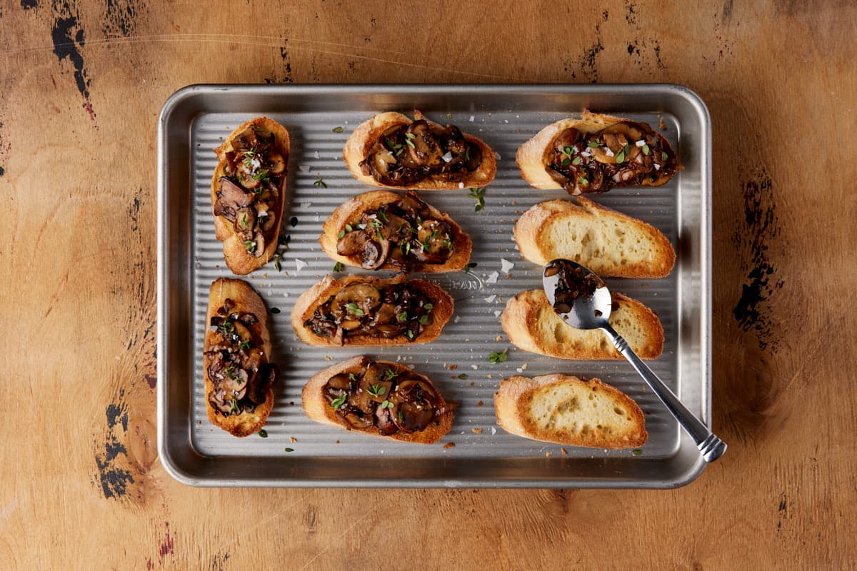 Sheet pan with pieces of mushroom bruschetta. 